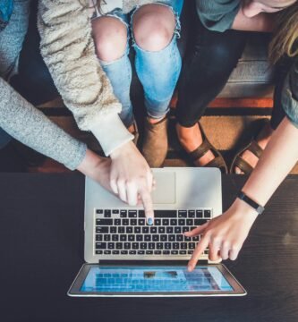 three person pointing the silver laptop computer